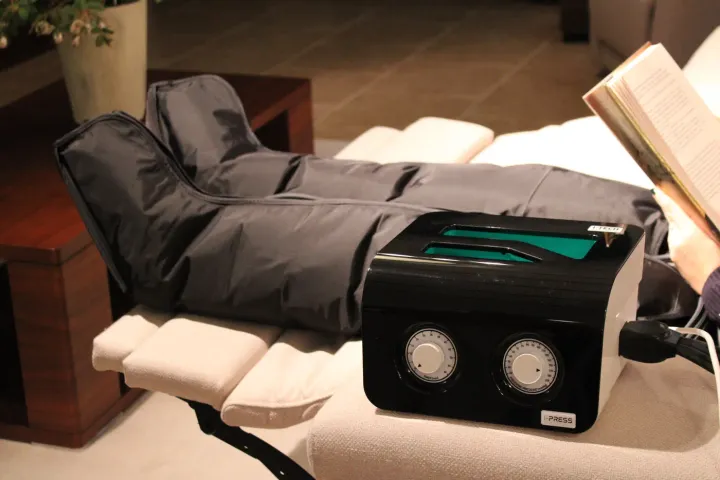 Equipo de presoterapia con perneras puestas, vista frontal durante una sesión en casa